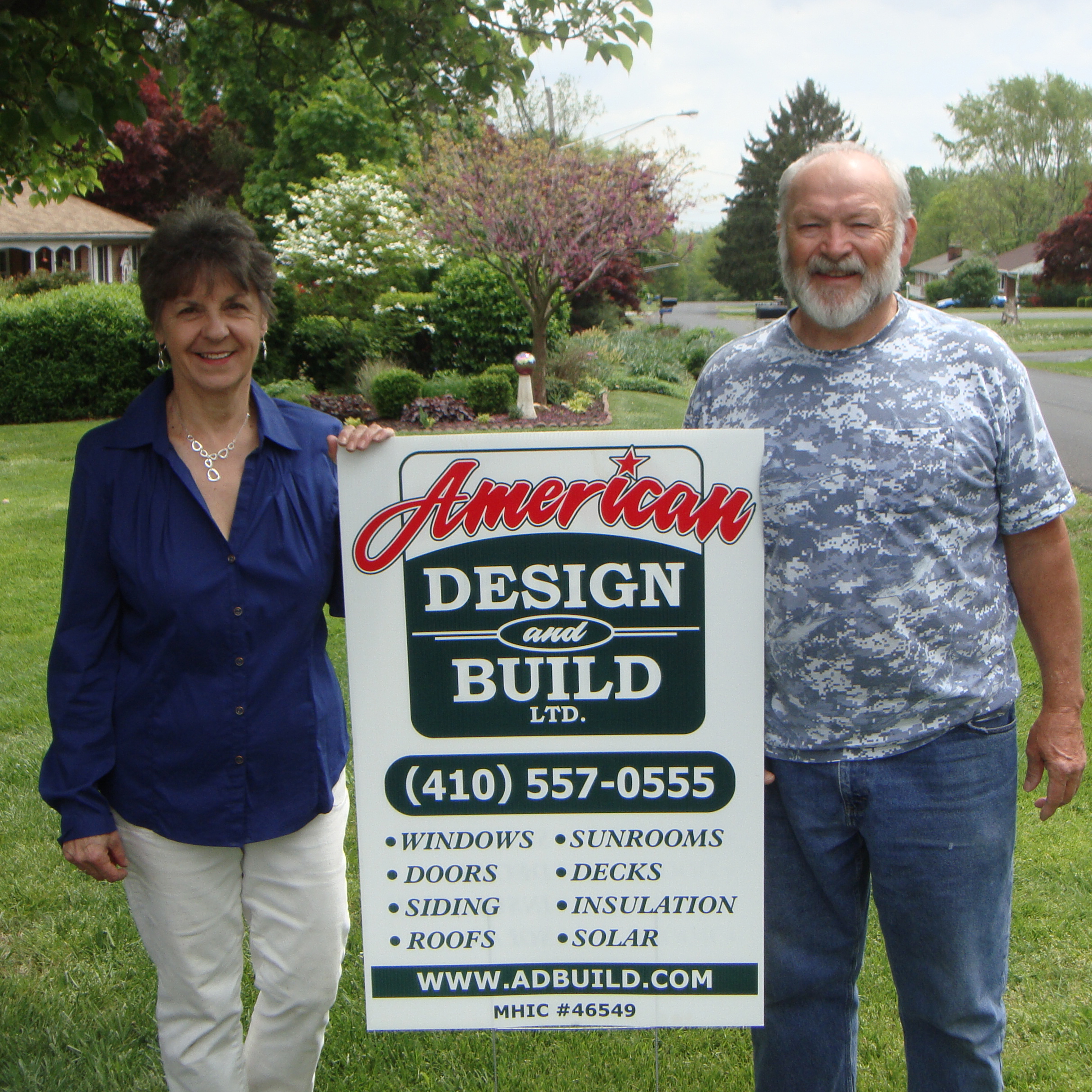 couple standing by yard sign